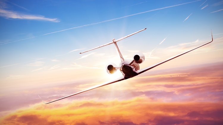 biz jet flying into sunset