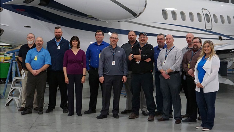 Employees standing in front of plane
